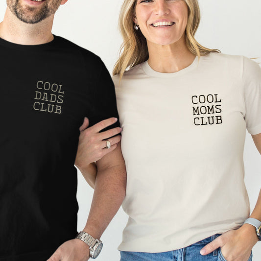 Two people wearing t-shirts with 'Cool Dads Club' and 'Cool Moms Club' text.