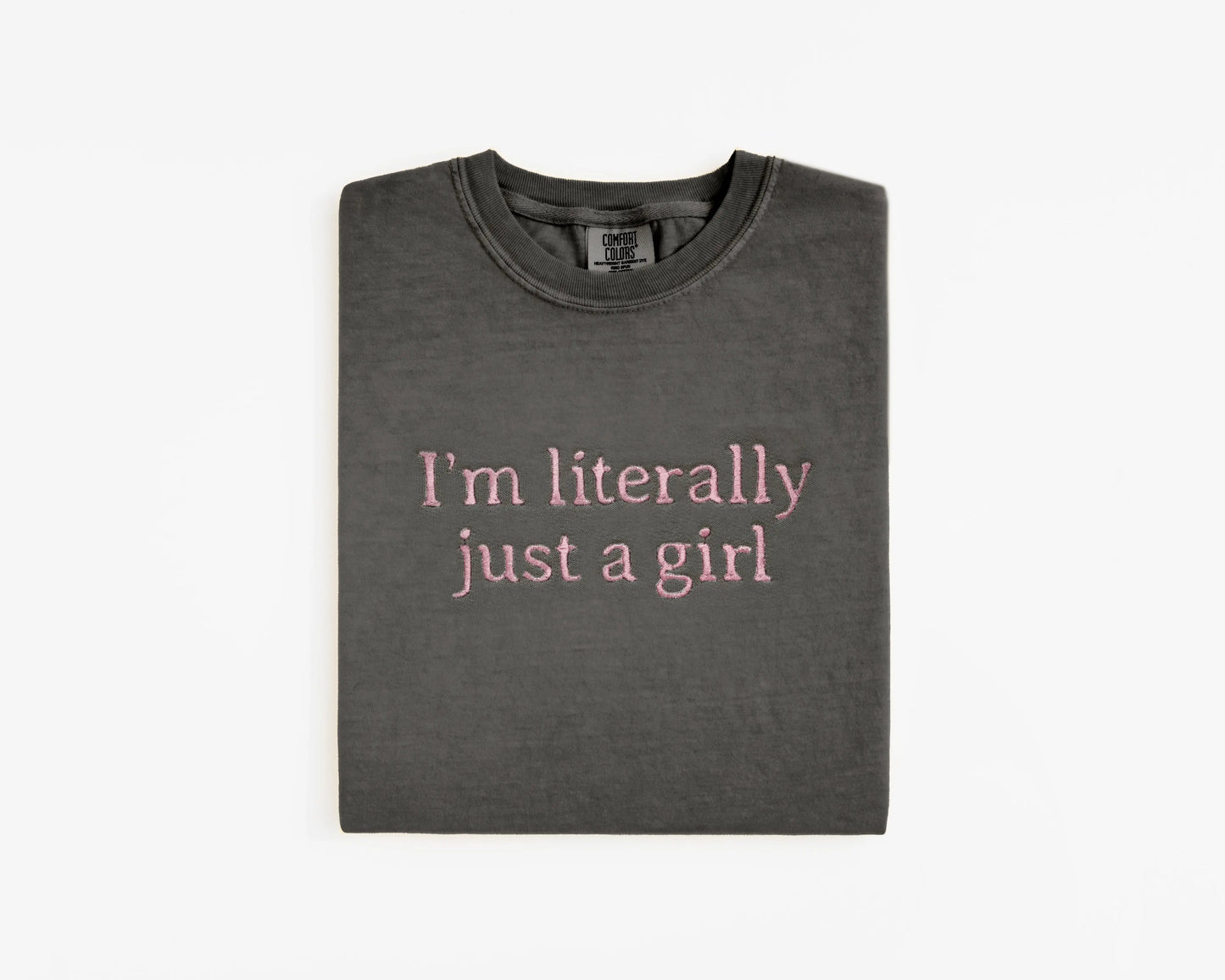 Folded dark gray t-shirt with pink text on a white background