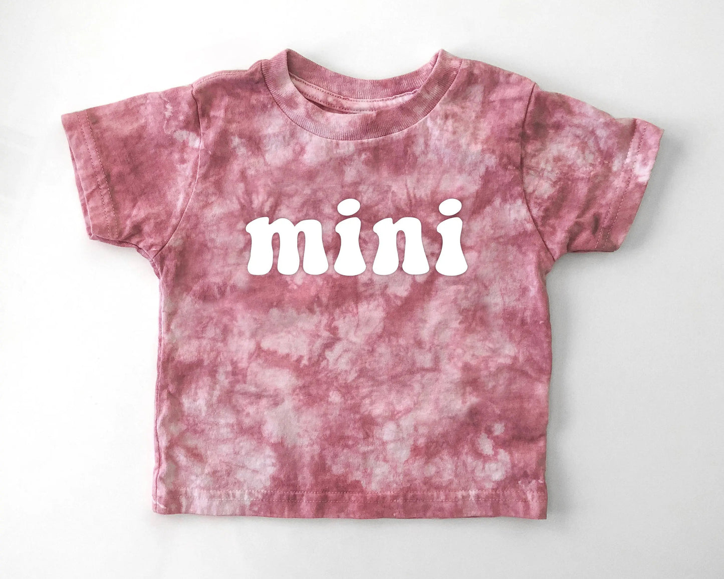 Pink tie-dye t-shirt with 'mini' text on a white background