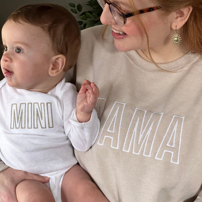 Mom and baby wearing matching mama and mini embroidered outfits