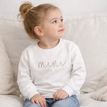 Mom and baby wearing matching mama and mini embroidered outfits