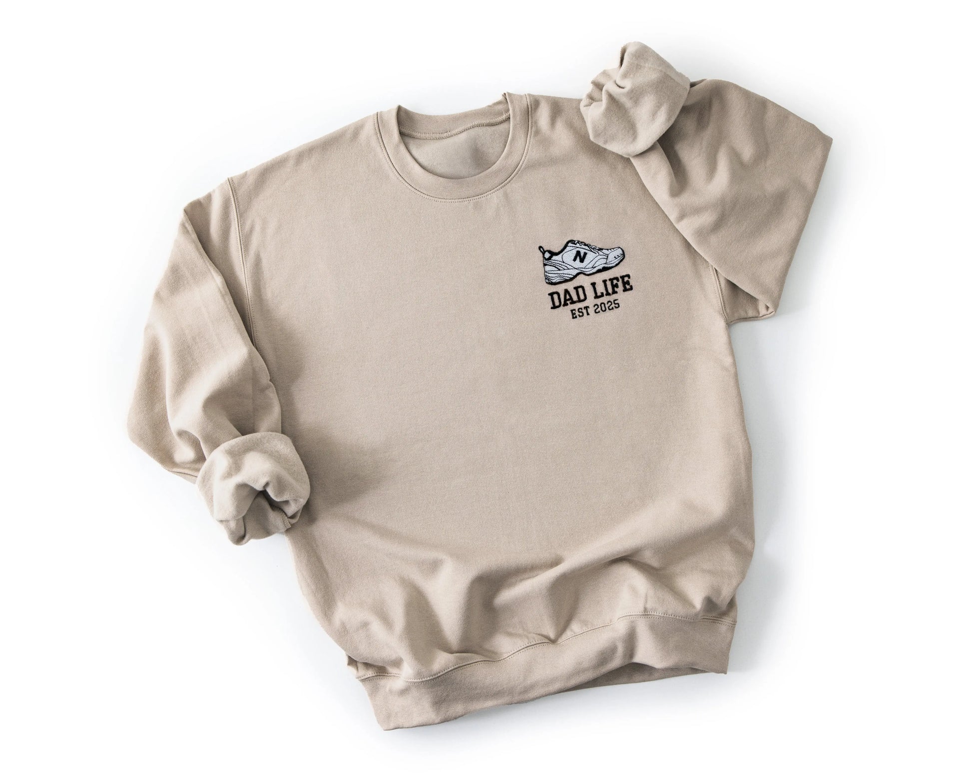 Beige dad life sweatshirt embroidered with new balance dad sneaker and est year. Best gift for new dads flatlay