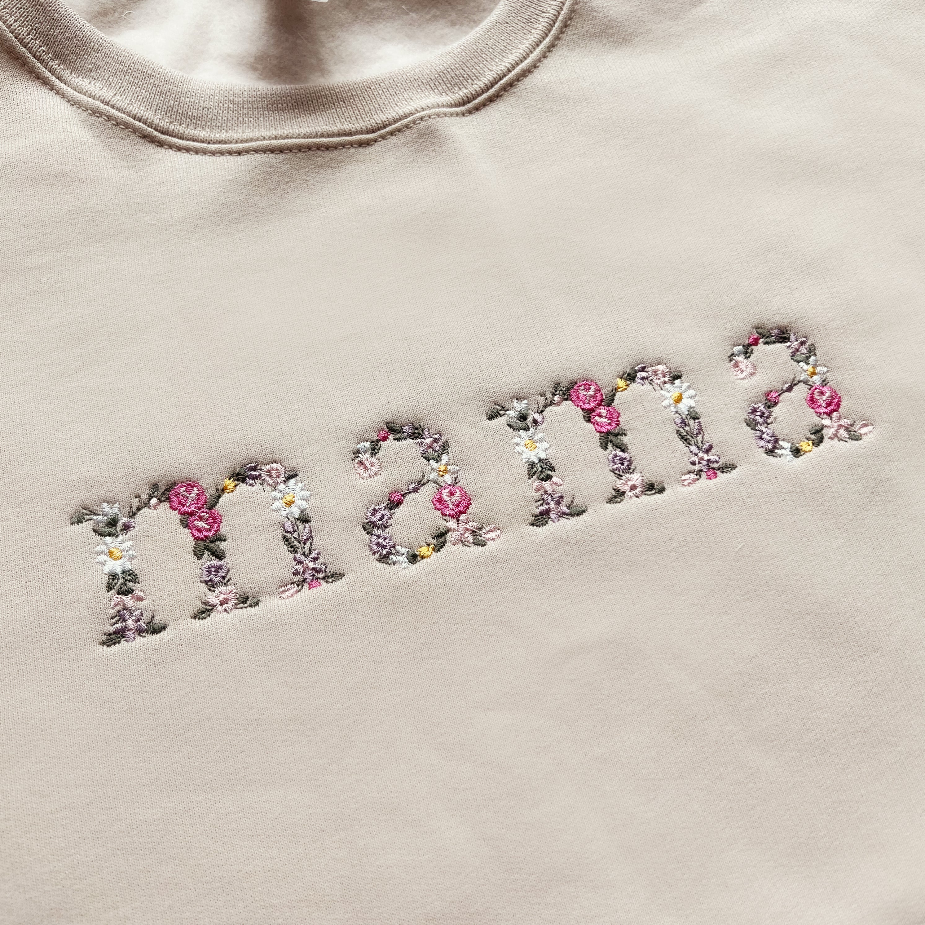 Close up of floral embroidery on mama and mini matching outfits