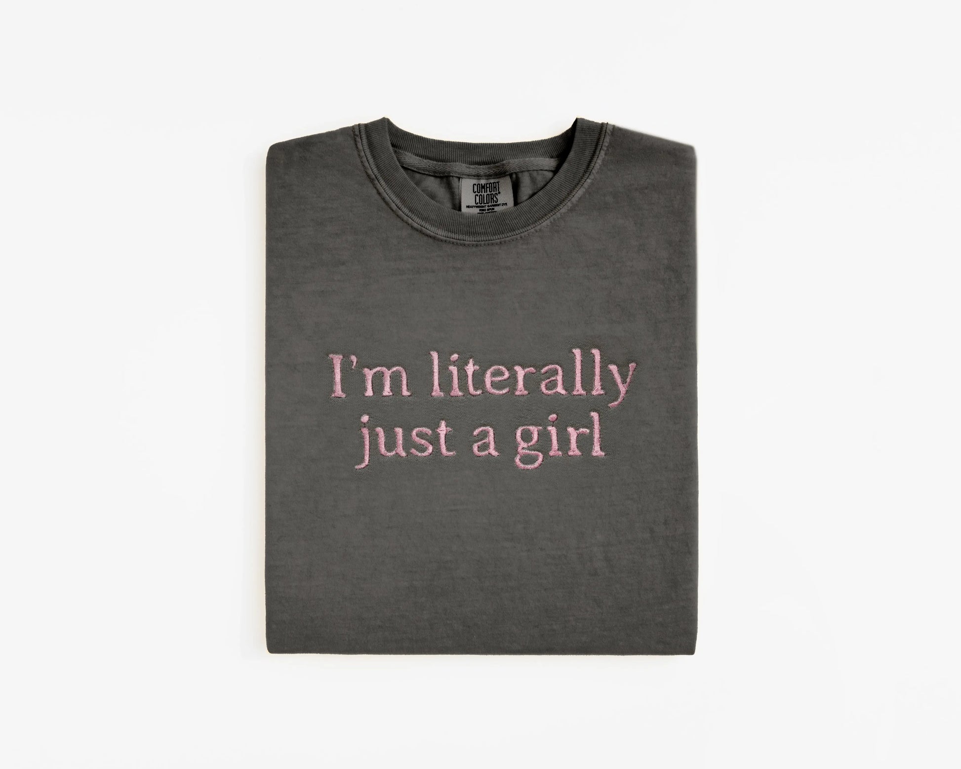 Folded dark gray t-shirt with pink text on a white background