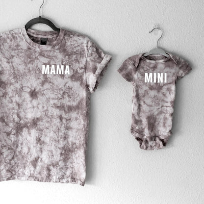 Tie-dye t-shirt and baby onesie with 'MAMA' and 'MINI' text on a white background