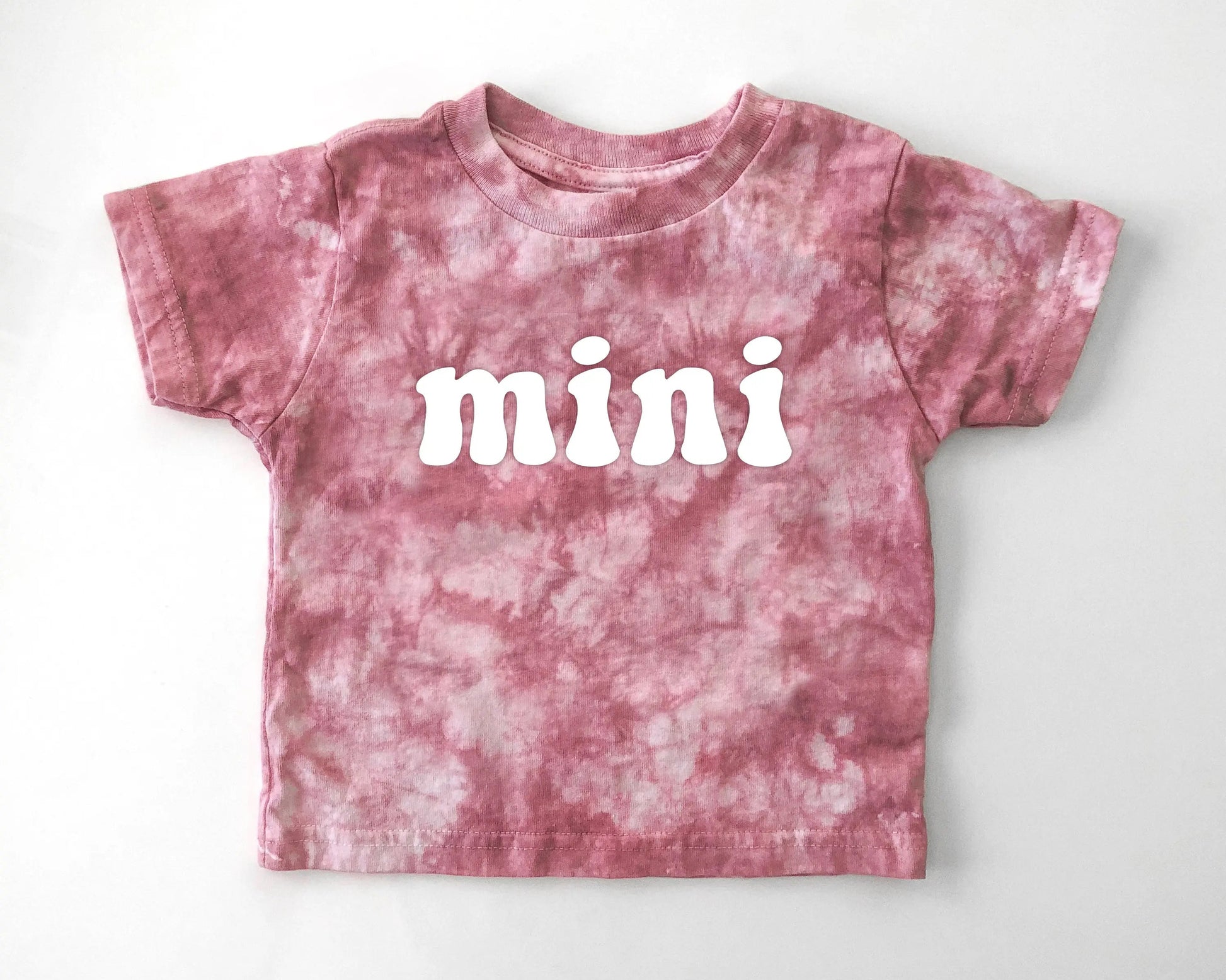 Pink tie-dye t-shirt with 'mini' text on a white background