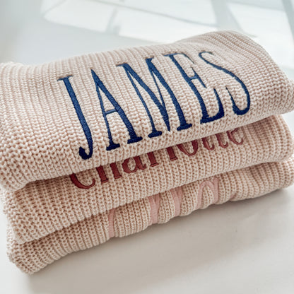 Custom baby name sweater romper made from soft beige cotton knit fabric with embroidered lettering