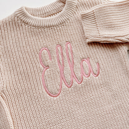 Close up of personalized embroidery on cotton baby sweater romper showing detailed stitching
