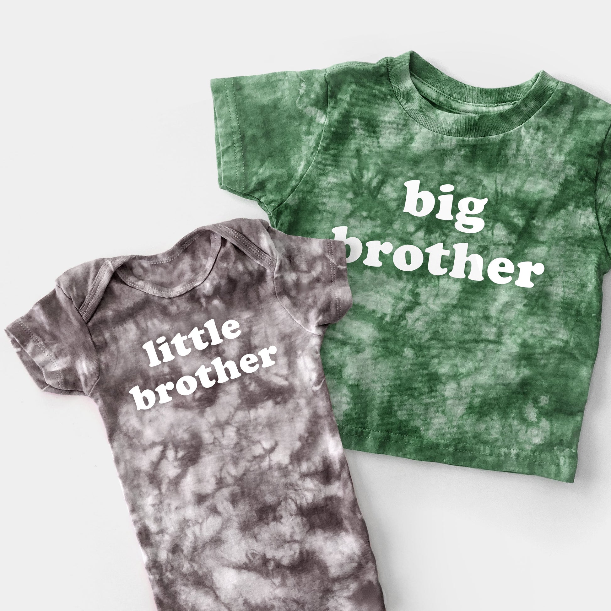 Green tie-dye shirt and gray tie-dye onesie with 'big brother' and 'little brother' text on a white background.
